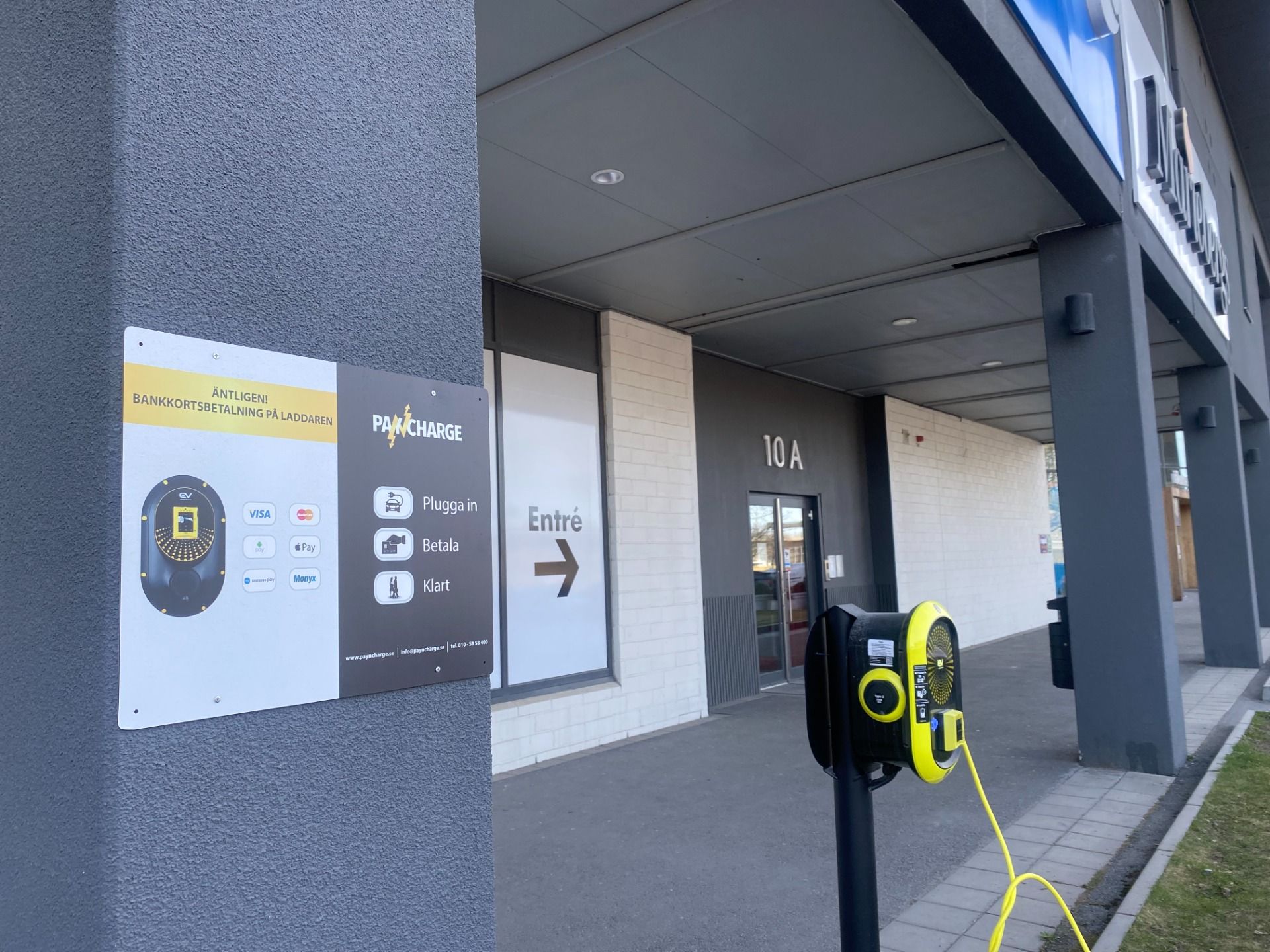 Electric vehicle charger with bank card payment outside a commercial building